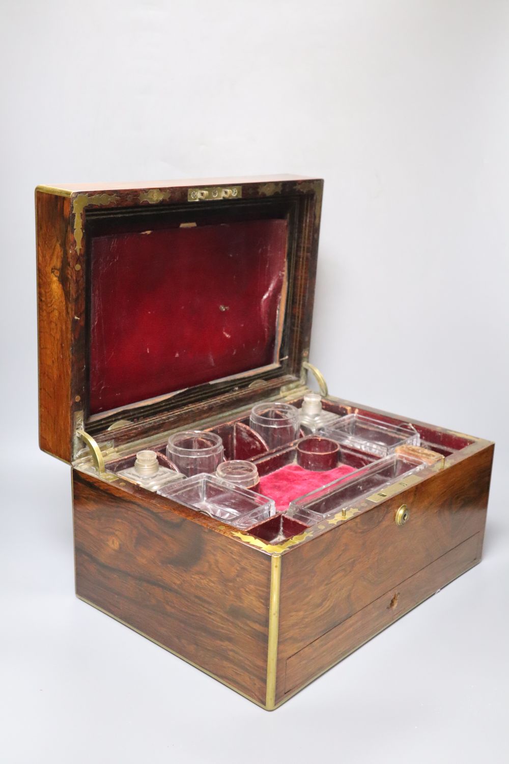 A Regency brass mounted rosewood toilet box, with glass contents and base drawer, width 36cm